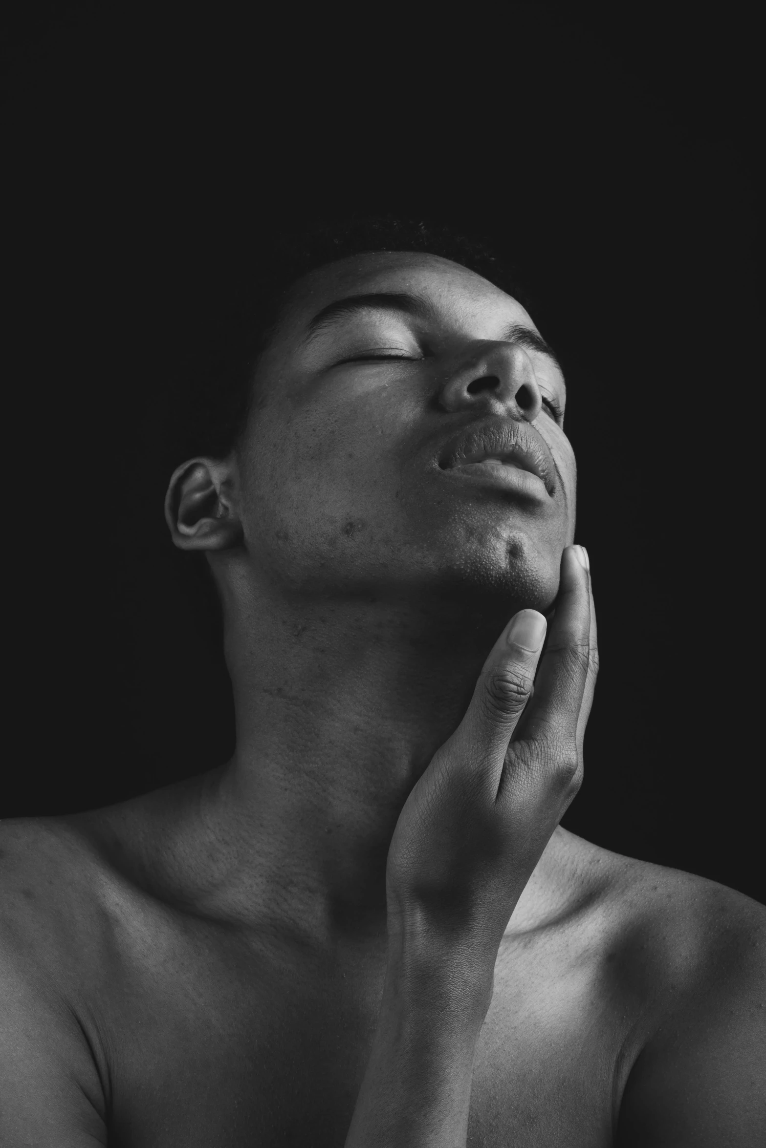 a black and white photo of a man with his eyes closed, inspired by Xanthus Russell Smith, pexels contest winner, hyperrealism, square masculine jaw, black teenage boy, bust with a long beautiful neck, african american