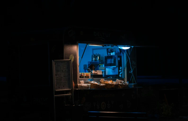 a food cart lit up at night in the dark, a portrait, pexels contest winner, blue backlight, morning sunlight, blue bioluminescence, nighthawks