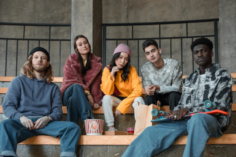 a group of people sitting on top of a wooden bench, trending on pexels, antipodeans, streetwear fashion, movie, sitting on couch, federation clothing