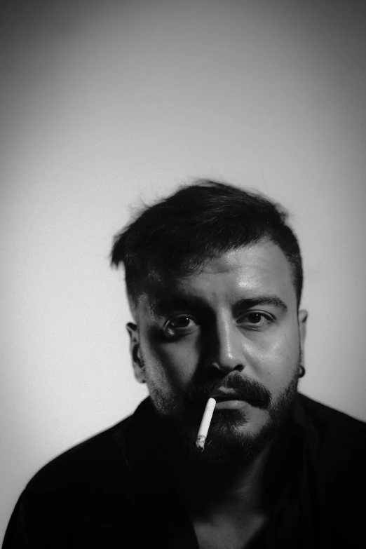 a man with a cigarette in his mouth, an album cover, inspired by Agnolo Gaddi, reddit, black & white photo, ((portrait)), demna gvasalia, jean deville