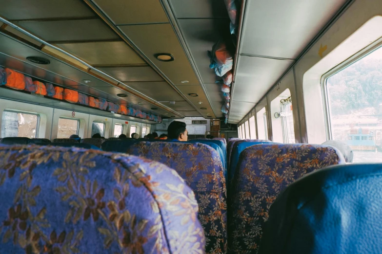 a group of people sitting next to each other on a train, unsplash, guangjian huang, ship interior, fan favorite, 2 5 6 x 2 5 6 pixels