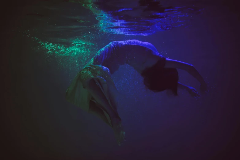 a person on a surfboard in the water, an album cover, inspired by Elsa Bleda, underwater in the ocean at night, deep dark purple waters, blue, lights