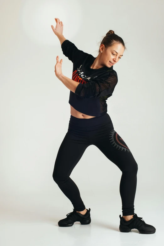 a woman in a black top and black leggings, arabesque, federation clothing, within radiate connection, ekaterina, sweat