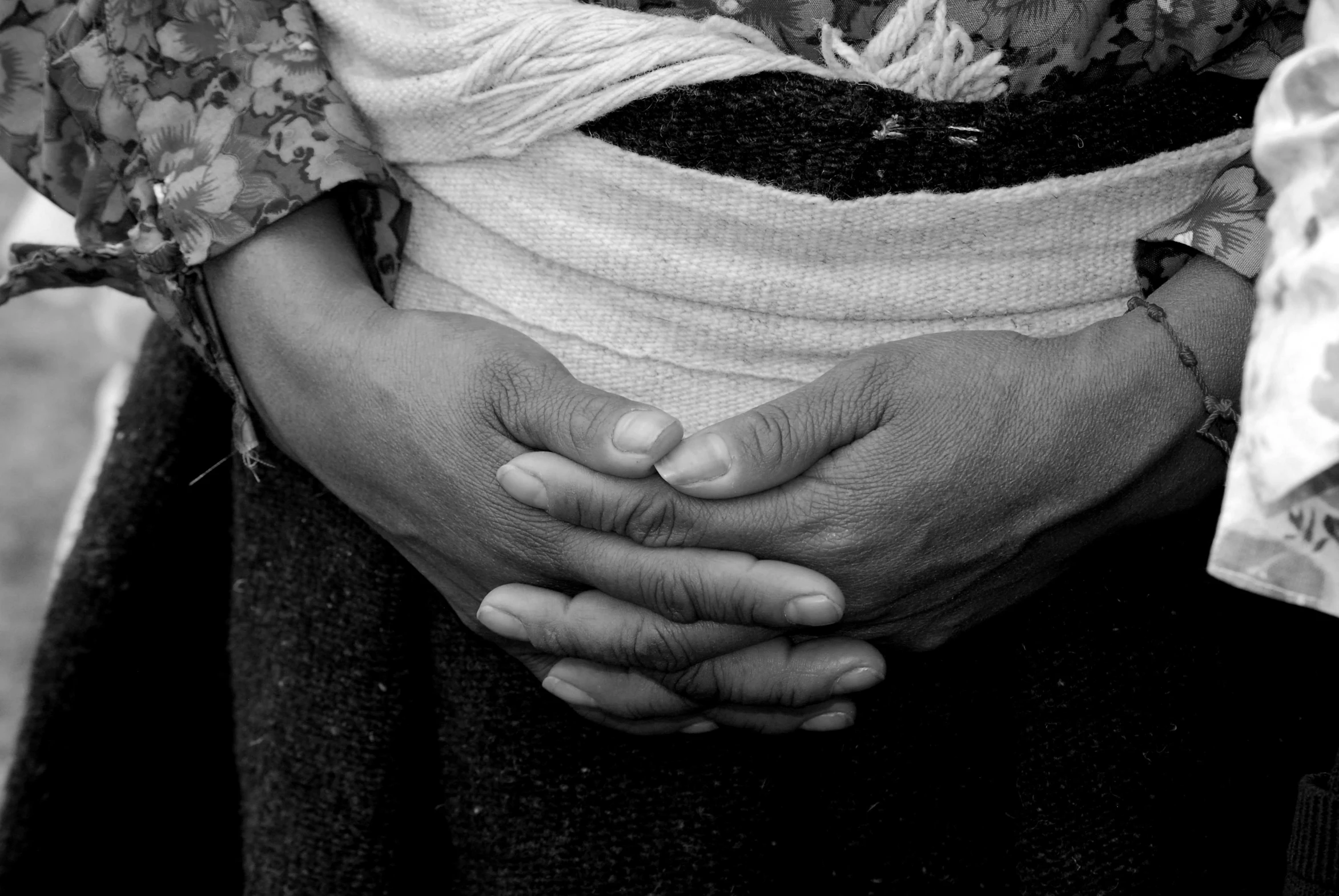 a black and white photo of a woman holding a baby, by Nathalie Rattner, flickr, highly detailed hands, mexico, closeup of arms, tight wrinkled cloath