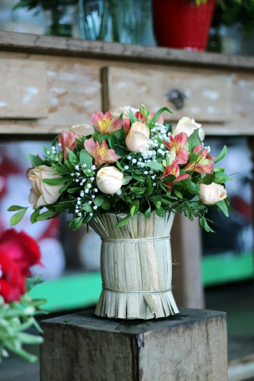 a vase filled with flowers sitting on top of a wooden table, inspired by François Boquet, renaissance, crown of peach roses, brazil, with soft bushes, wrapped in flowers