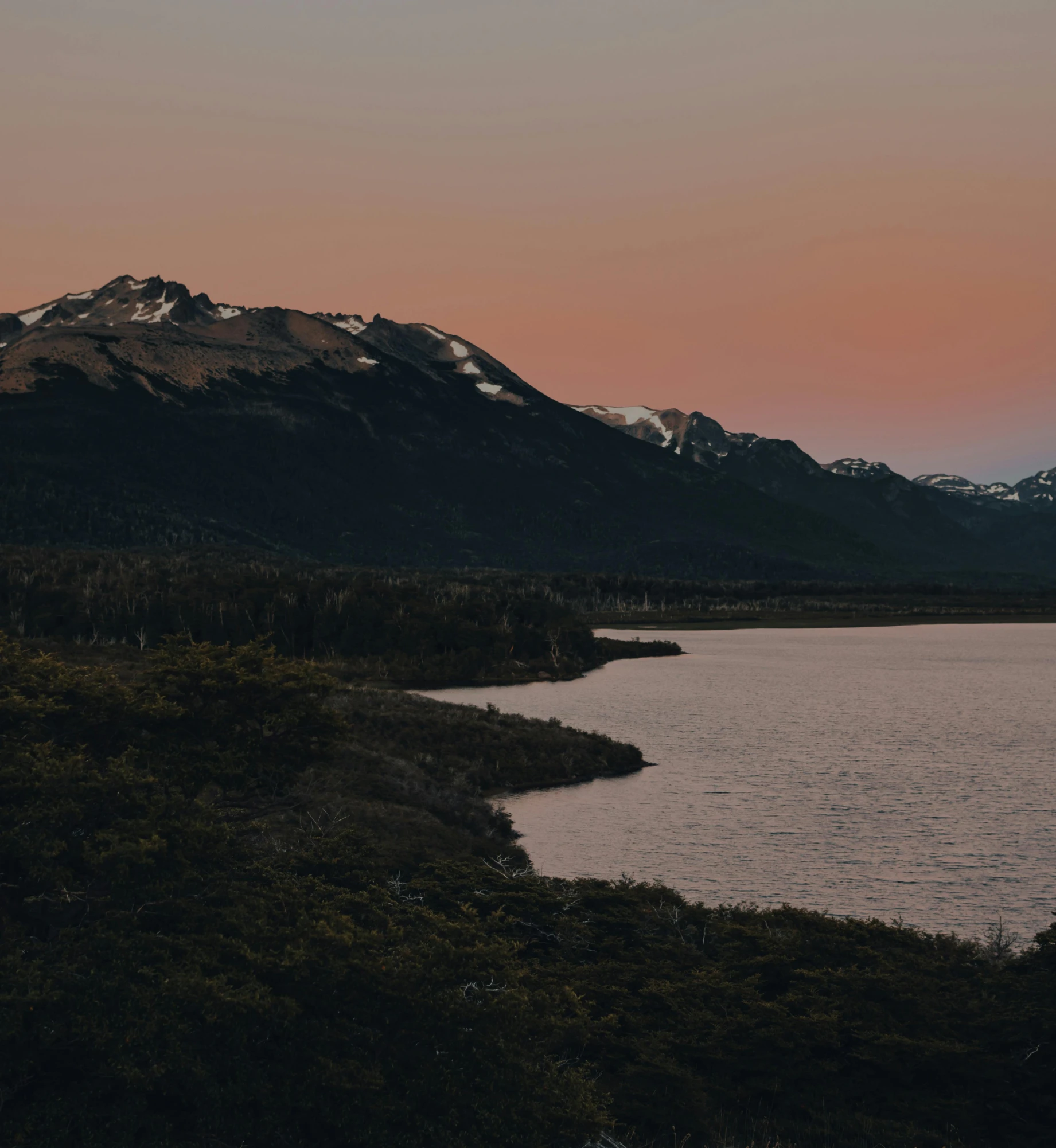 a body of water with mountains in the background, by Elsa Bleda, in the evening, patagonian, 8 k cinematic, sunset photo