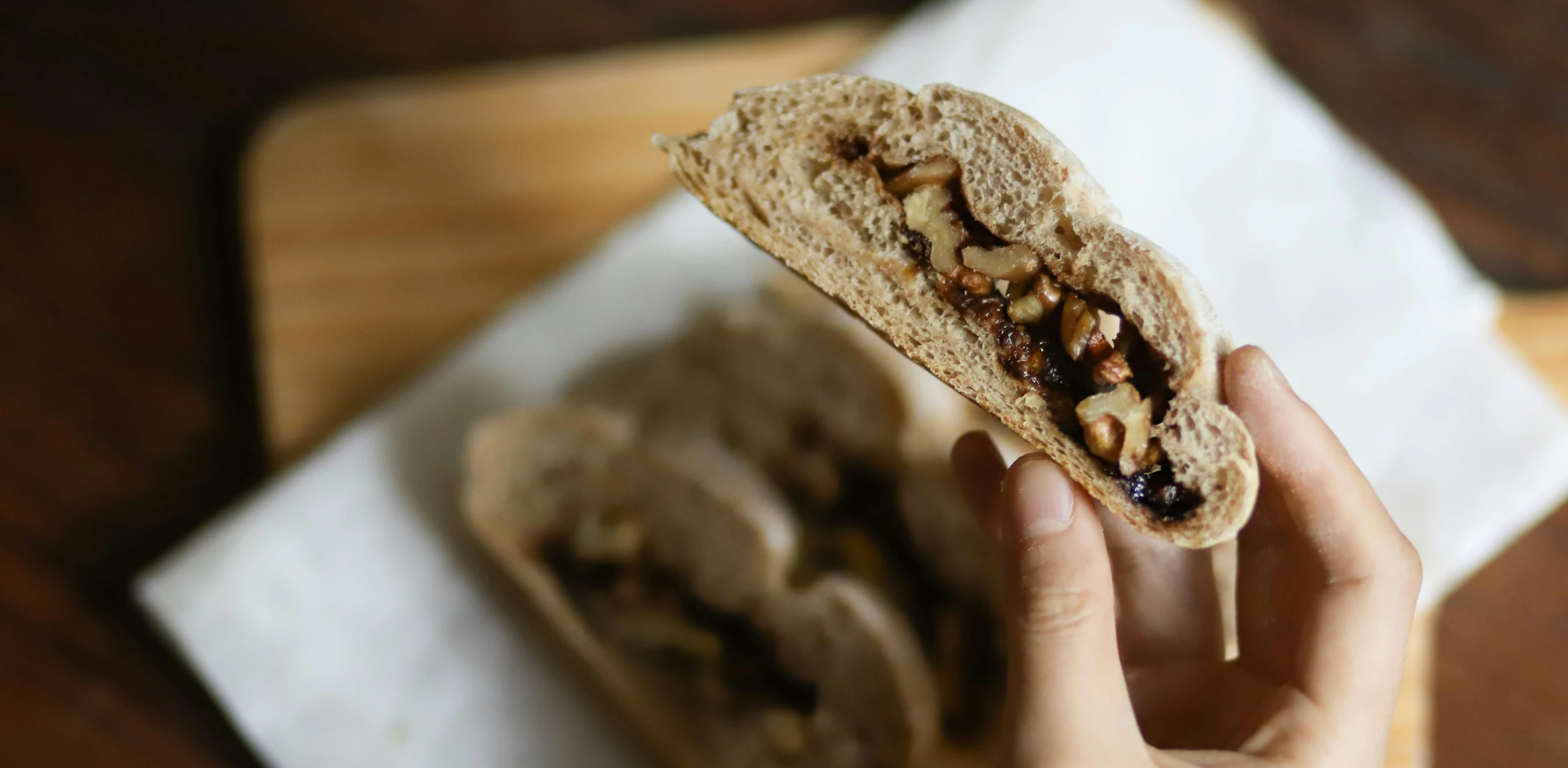 a close up of a person holding a sandwich, by Emma Andijewska, pexels contest winner, renaissance, walnuts, sichuan, steampank style, background image