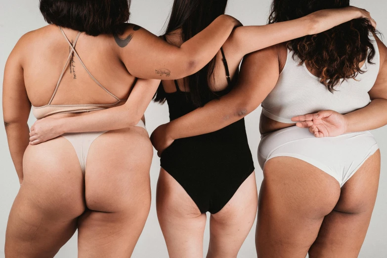 a group of women standing next to each other, by Matija Jama, trending on pexels, renaissance, curvy accentuated booty, body hair, wearing leotard, piled around