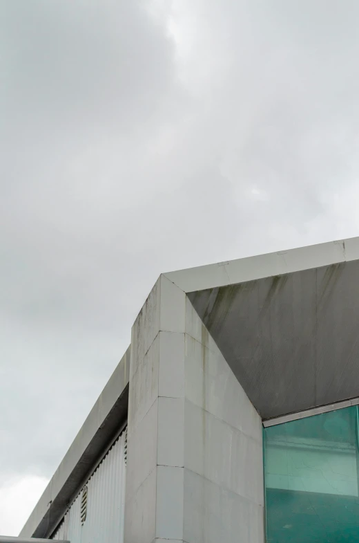 a man riding a skateboard up the side of a building, a minimalist painting, inspired by Tadao Ando, unsplash, brutalism, overcast gray skies, high detail photograph, square nose, medical research facility