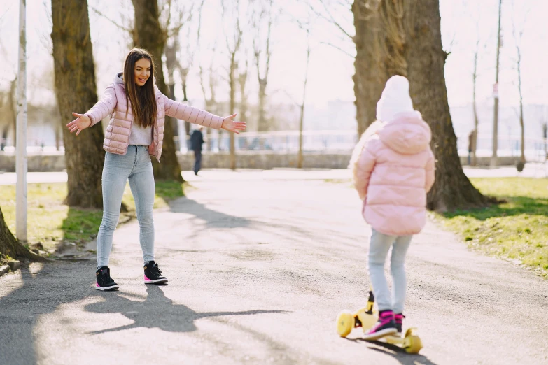 a woman teaching a young girl how to ride a skateboard, by Emma Andijewska, pexels contest winner, park in background, spring early, thumbnail, hoverboard