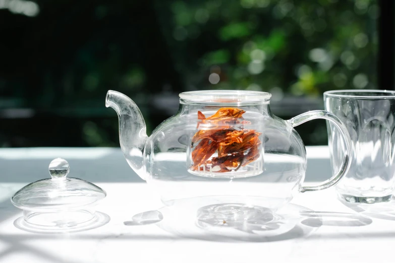 a glass tea pot sitting on top of a table, inspired by Weiwei, bhut jolokia, 3 - piece, al fresco, clarity