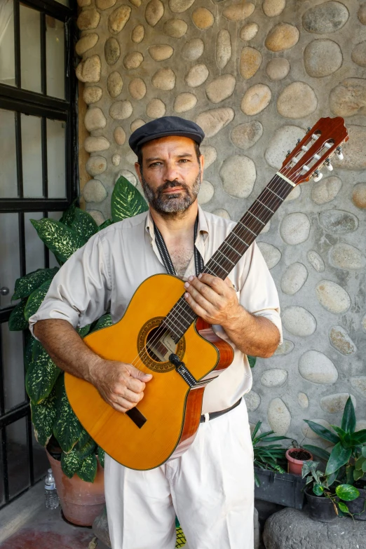 a man holding a guitar in front of a stone wall, portrait of danny gonzalez, 15081959 21121991 01012000 4k, full frontal portrait, square