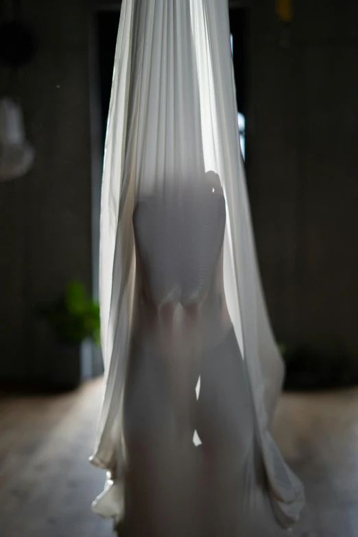 a white mannequin sitting on top of a wooden floor, a marble sculpture, inspired by Maciej Kuciara, unsplash, light and space, silks, hanging upside down, close-up shot from behind, soft light - n 9