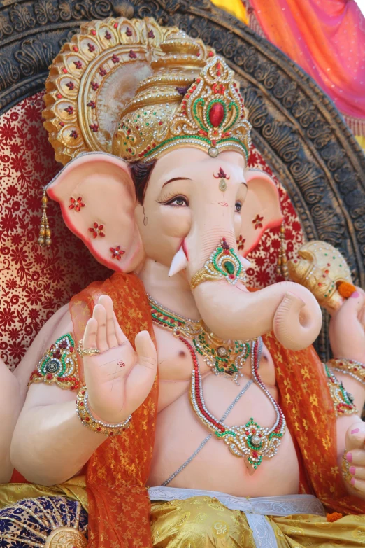 a close up of a statue of an elephant, ganesha, waving, wearing an ornate outfit, square