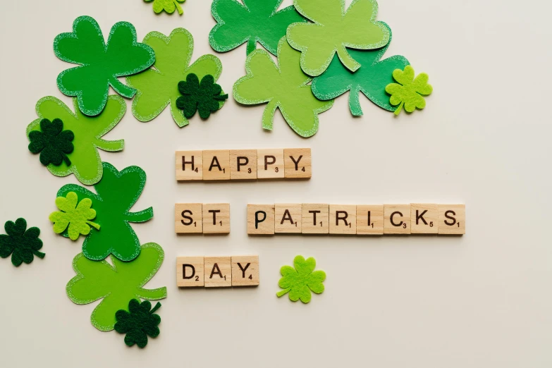 wooden blocks spelling happy st patrick's day surrounded by shamrocks, trending on unsplash, background image, instagram picture, abcdefghijklmnopqrstuvwxyz, on a pale background