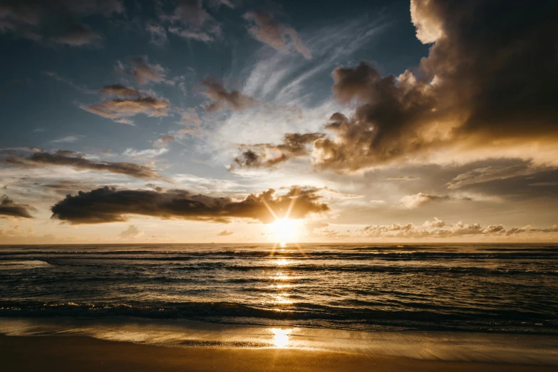 the sun is setting over the water on the beach, by Niko Henrichon, pexels contest winner, gold coast australia, kauai, sunrays between clouds, transparent background