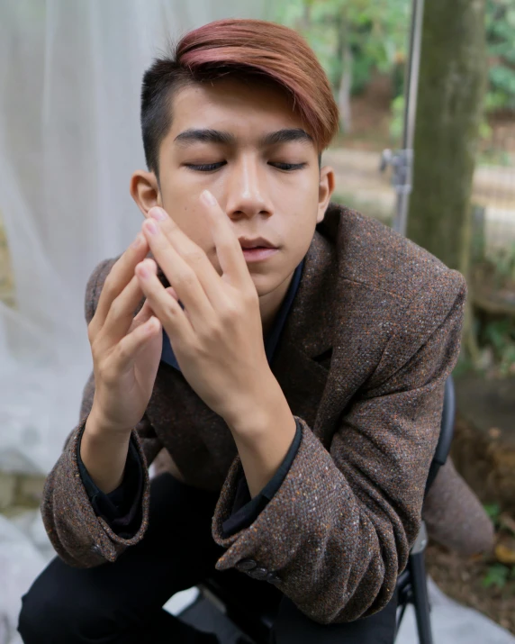 a man sitting on a chair with his eyes closed, inspired by Yu Zhiding, unsplash, sumatraism, androgynous face, partially cupping her hands, ((portrait)), lgbtq