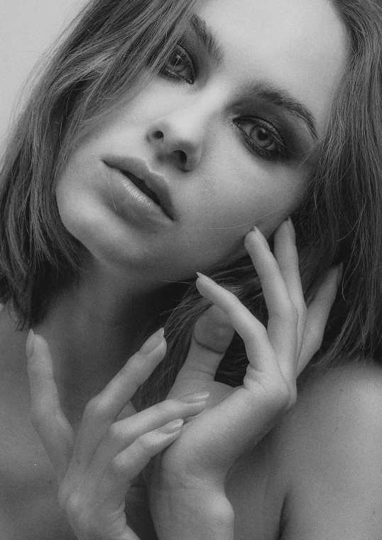 a black and white photo of a woman, inspired by Peter Basch, trending on pexels, photorealism, ana de armas, hands on face, photo of a model, pale skin and purple eyes