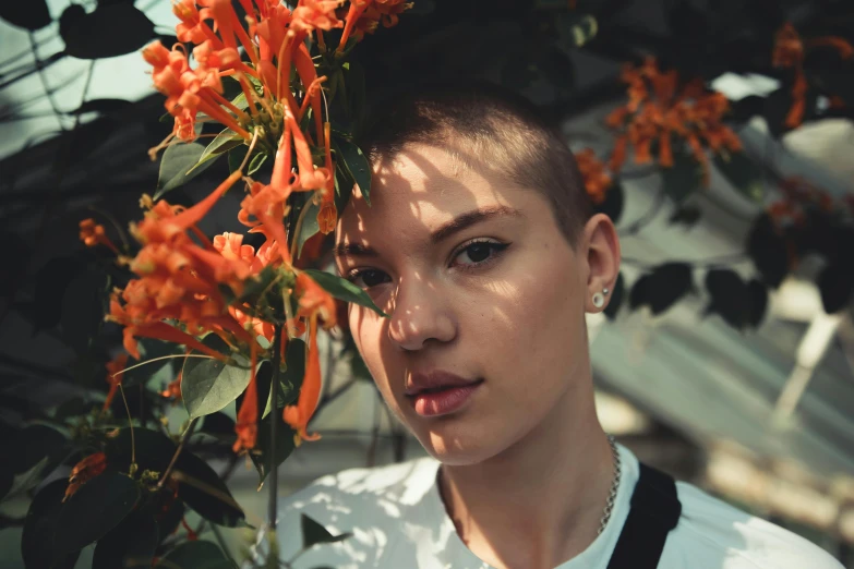 a woman standing in front of a bunch of flowers, inspired by Elsa Bleda, pexels contest winner, antipodeans, half shaved haircut, portrait of max caulfield, 18 years old, orange flowers