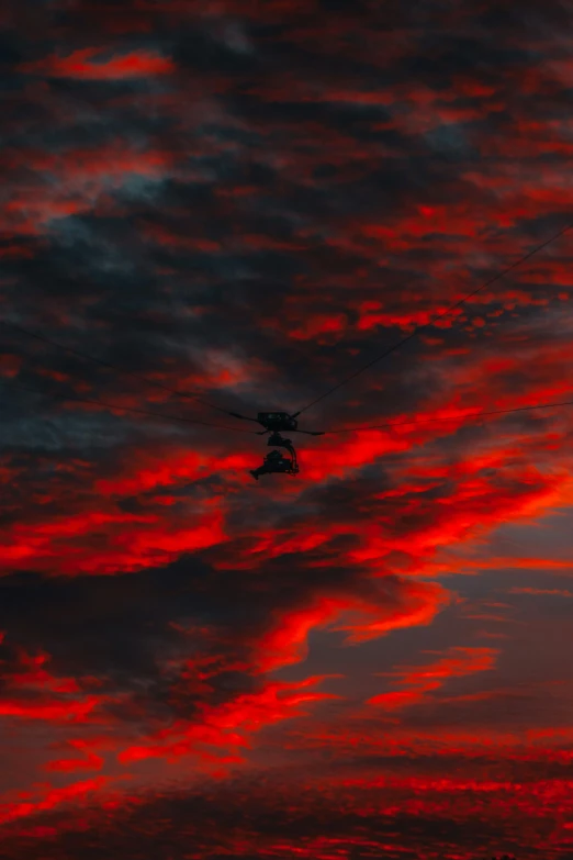 a plane that is flying in the sky, a picture, by Steven Belledin, pexels contest winner, red eerie sky, black helicopters, avatar image, iridescent clouds