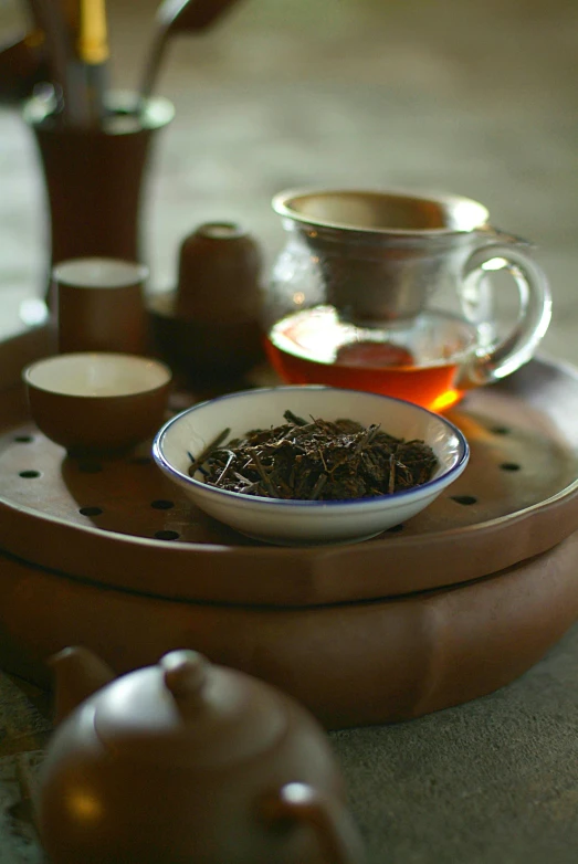 a bowl of tea sitting on top of a wooden tray, inspired by Li Shixing, brown, slide show, vanilla, herb