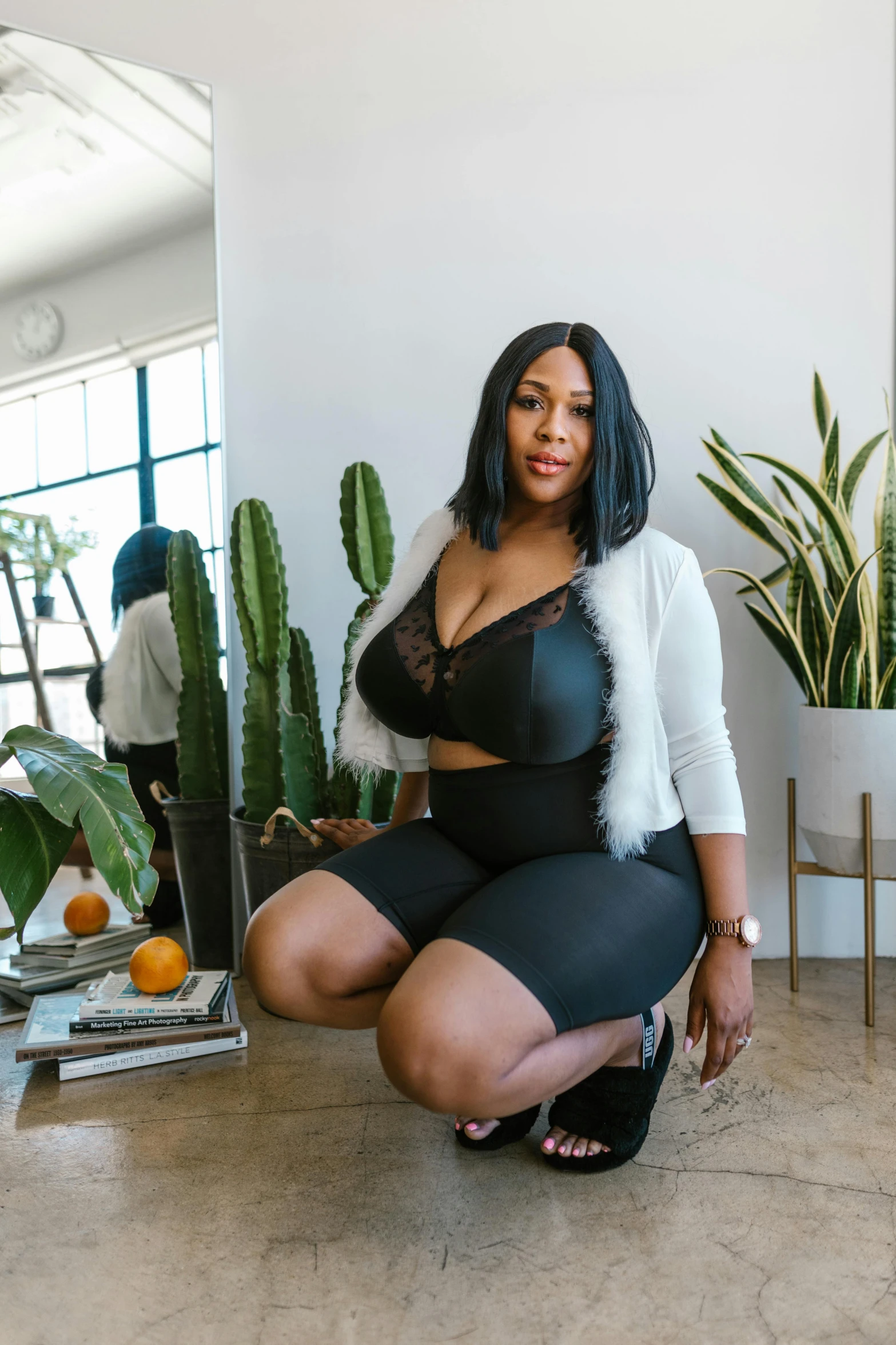 a woman sitting on the floor next to a potted plant, featured on instagram, renaissance, nicki minaj curvy, model is wearing techtical vest, standing on a desk, tight black tank top and shorts