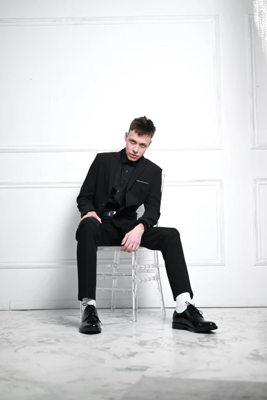 a man in a suit sitting on a chair, an album cover, inspired by Kristian Kreković, trending on pexels, casual black clothing, rickroll, full body model, androgynous