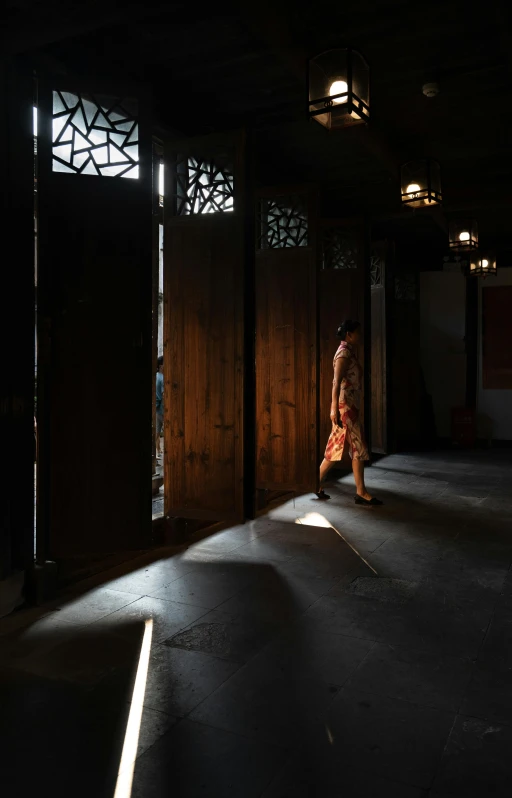 a person walking through a dimly lit room, a picture, unsplash contest winner, light and space, traditional chinese, in a old house. hyper realistic, the girl and the sun, taken in the late 2010s