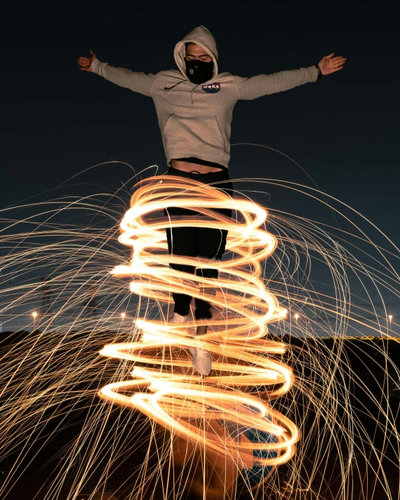 a man standing on top of a pile of fire, pexels contest winner, twinkling and spiral nubela, aura jared and wires, flash photo, pose 4 of 1 6