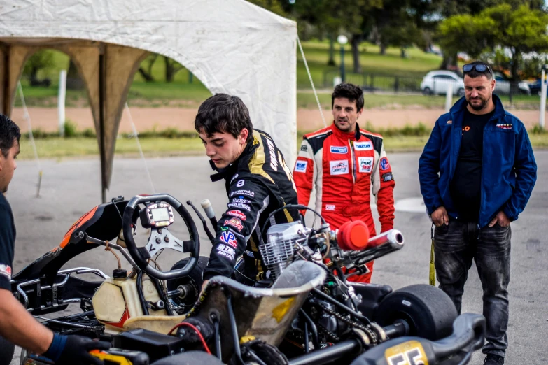 a group of men standing around a motorcycle, f 1 driver charles leclerc, sideways glance, lachlan bailey, avatar image