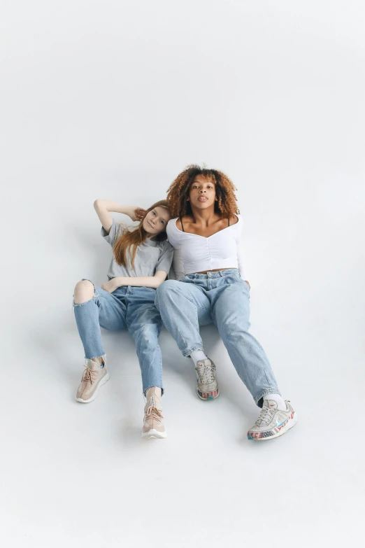 a couple of women sitting on top of each other, trending on pexels, renaissance, ( ( ( wearing jeans ) ) ), plain background, 15081959 21121991 01012000 4k, instagram picture