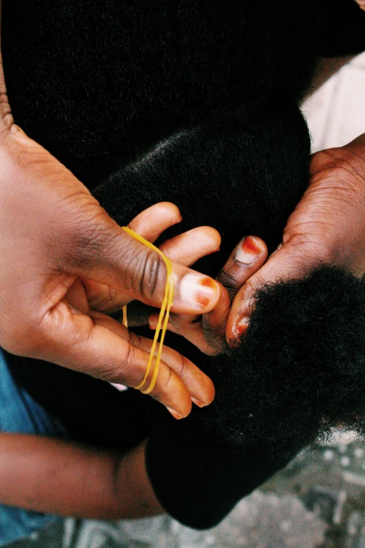 a close up of a person holding a child's hand, by Ingrida Kadaka, process art, hair jewellery, golden threads, afro, ignant