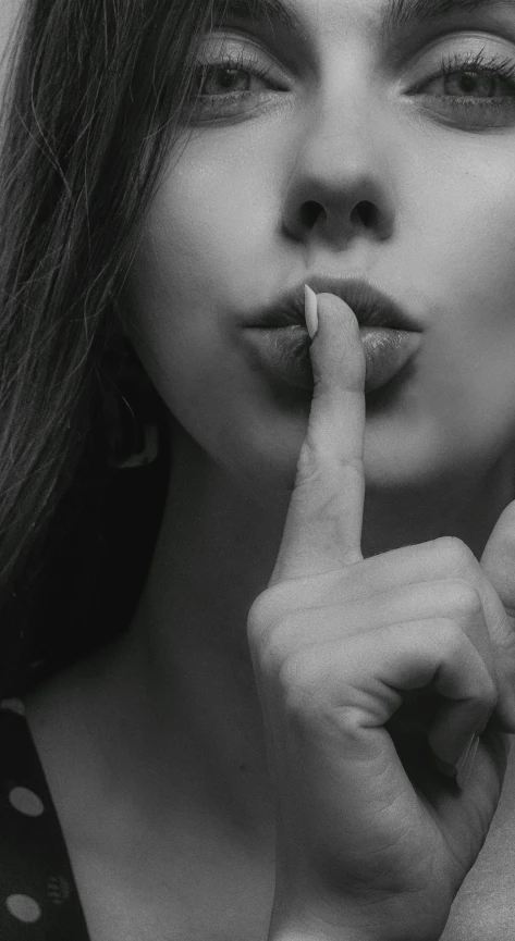 a woman holding her finger to her lips, a black and white photo, conceptual art, closeup of an adorable, secret <, “ sensual, instagram photo