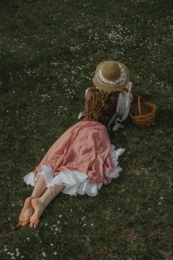 a woman laying on top of a lush green field, inspired by Konstantin Somov, pexels contest winner, renaissance, with straw hat, dressed in a pink dress, petite girl, victorian style costume