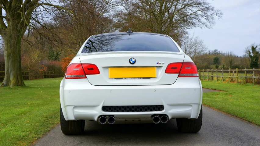 a white bmw car parked on the side of a road, by Tom Bonson, pexels contest winner, rear view, in 2 0 1 2, modified, rule of three