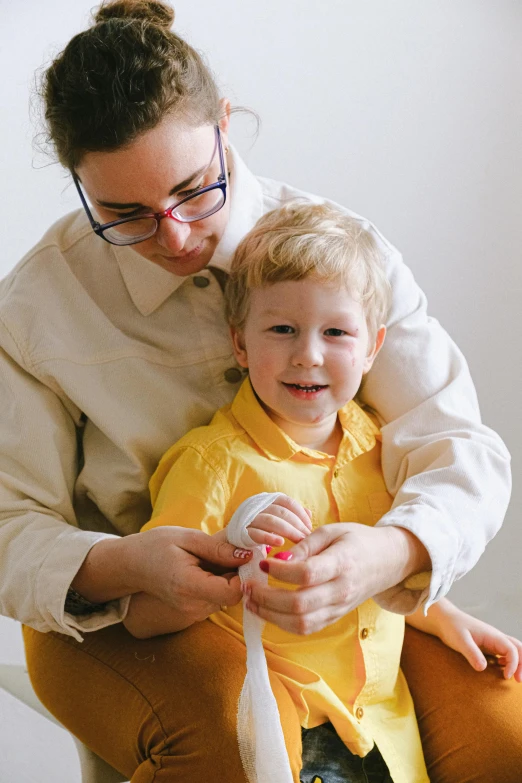 a woman sitting next to a child holding a toothbrush, bandage on arms, with a stethoscope, subtle detailing, softplay