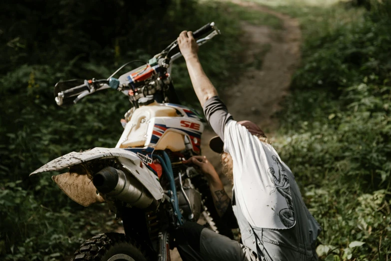 a man riding on the back of a dirt bike, a picture, unsplash, cottagecore hippie, celebration, maintenance photo, gray