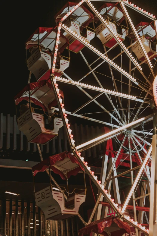 a ferris wheel in front of a building at night, at night