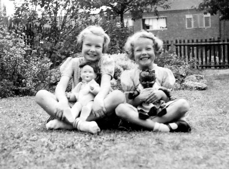 a black and white photo of two girls and a baby, by Phyllis Ginger, flickr, plastic doll, sitting in the garden, with a twin, bbc