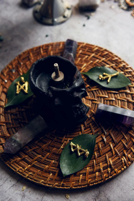 a close up of a plate with a candle on it, vanitas, skull earings, healing pods, pestle, in dark robes with gold accents