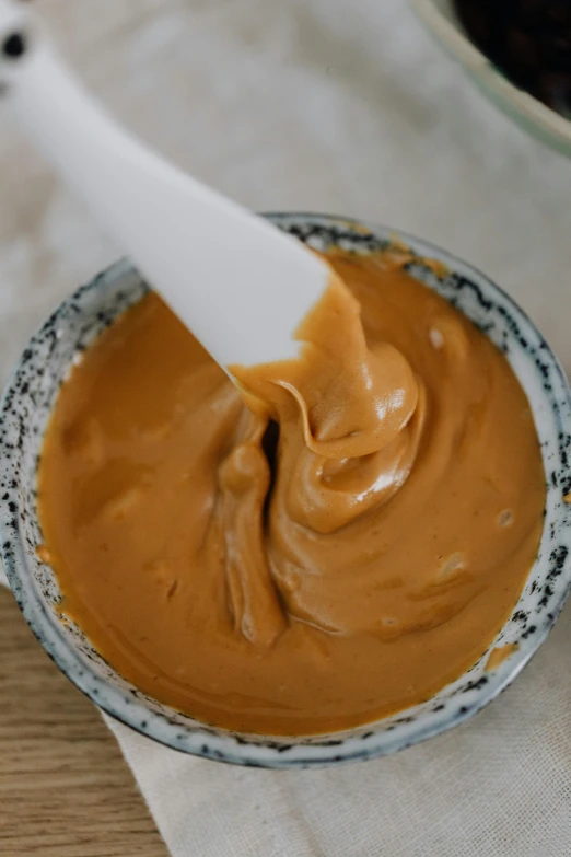 a bowl of peanut butter next to a bowl of raisin raisin raisin raisin raisin raisin raisin raisin raisin, unsplash, embossed paint, thumbnail, spatula, red ocher