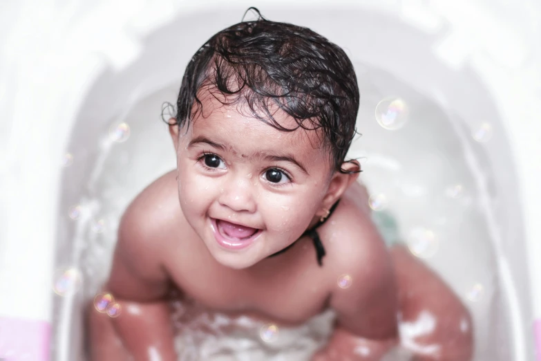 a close up of a baby in a bath tub, by Bernardino Mei, pexels contest winner, vinayak, thumbnail, bubbling skin, islamic