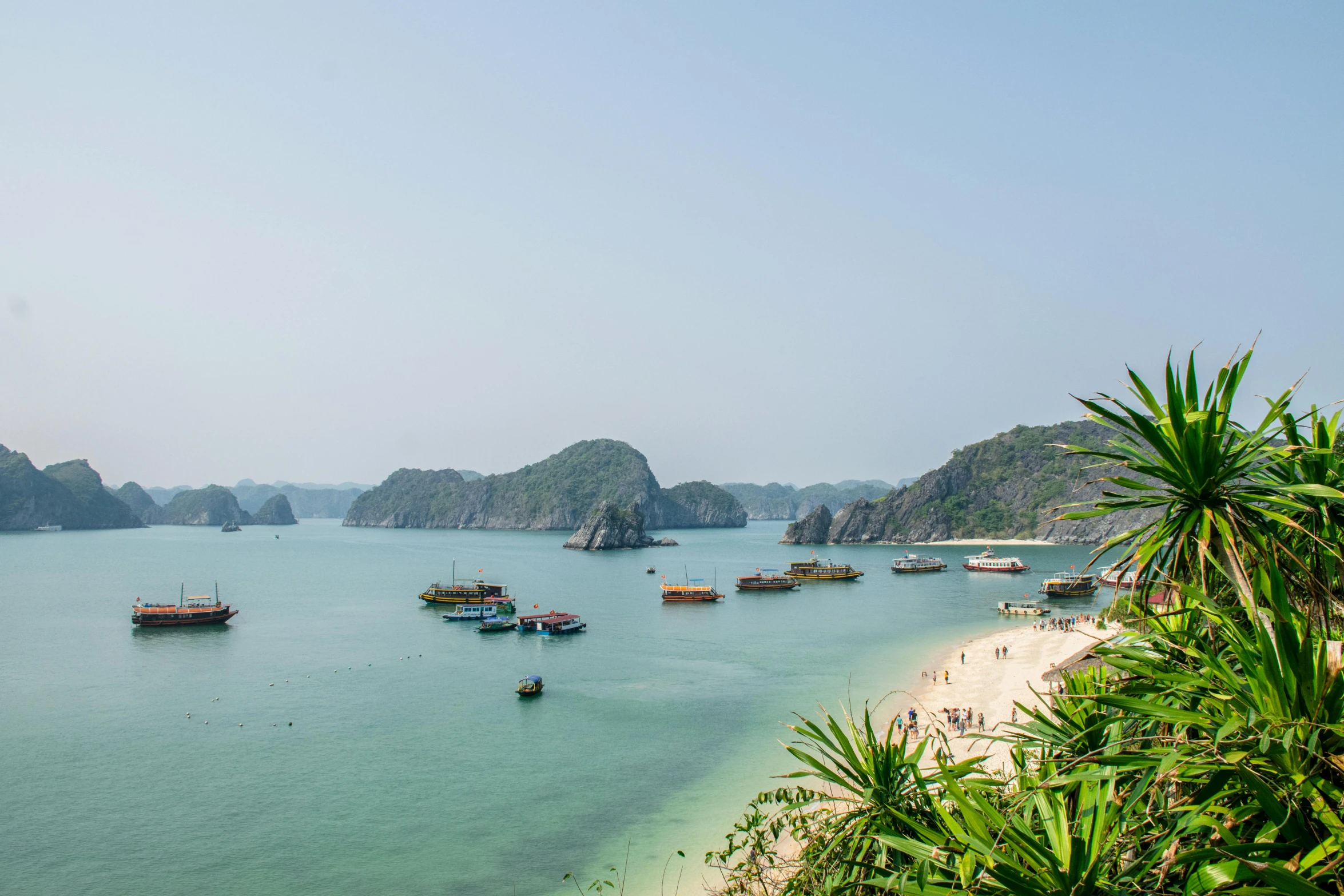 a group of boats floating on top of a body of water, by Carey Morris, pexels contest winner, vietnam, overlooking the beach, thumbnail, two medium sized islands