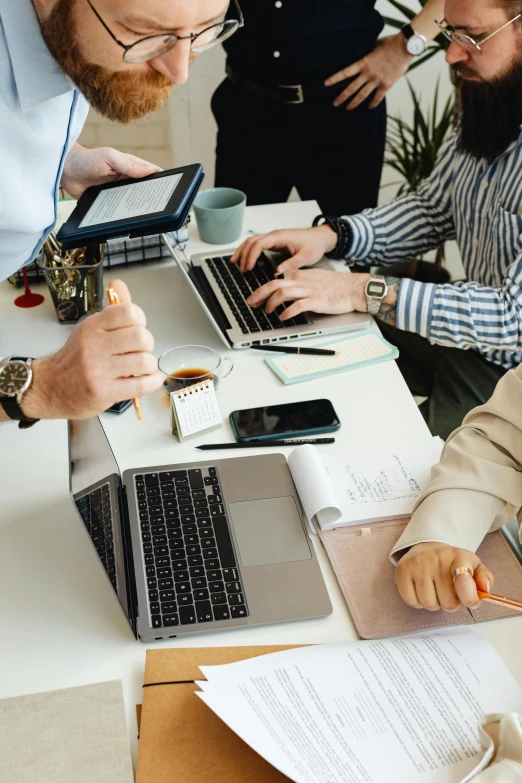 a group of people sitting around a table with laptops, trending on pexels, arbeitsrat für kunst, high quality photo, office background, medium closeup, thumbnail