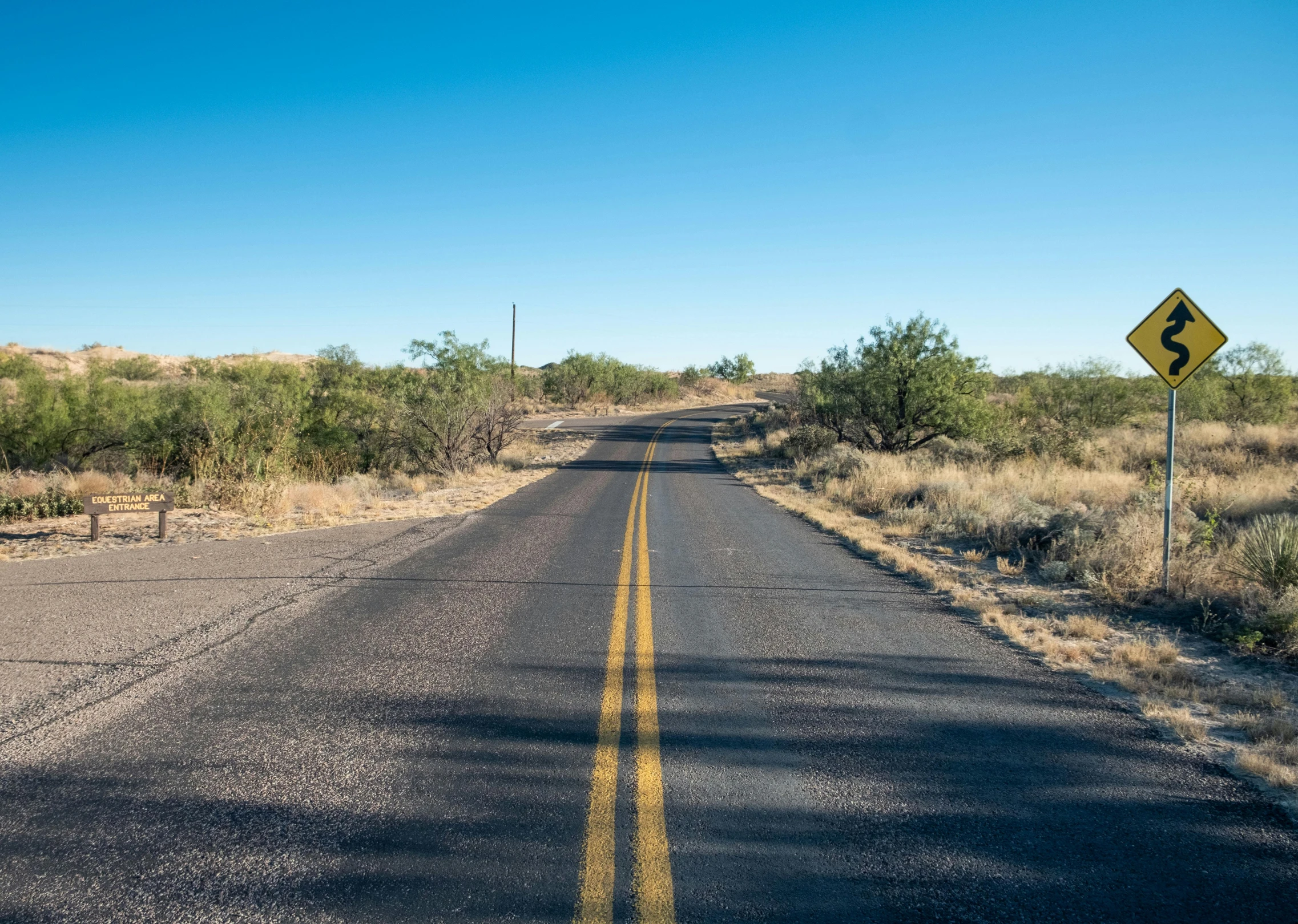 a yellow street sign sitting on the side of a road, by Linda Sutton, unsplash, realism, arizona desert, avatar image, hilly road, tar roads