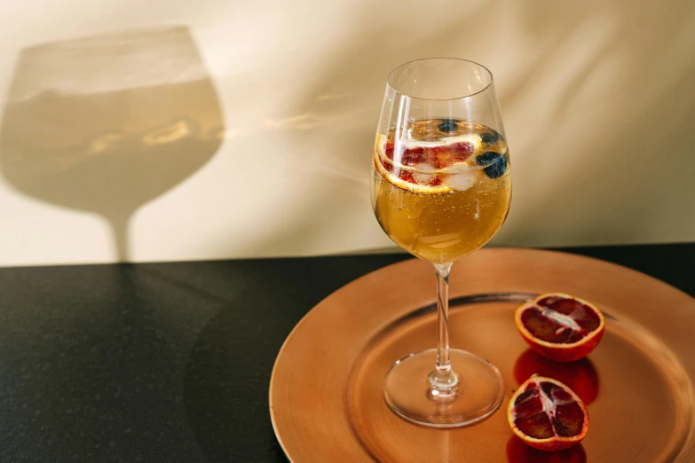 a glass of wine sitting on top of a plate, on a marble pedestal, red blue and gold color scheme, manuka, persephone