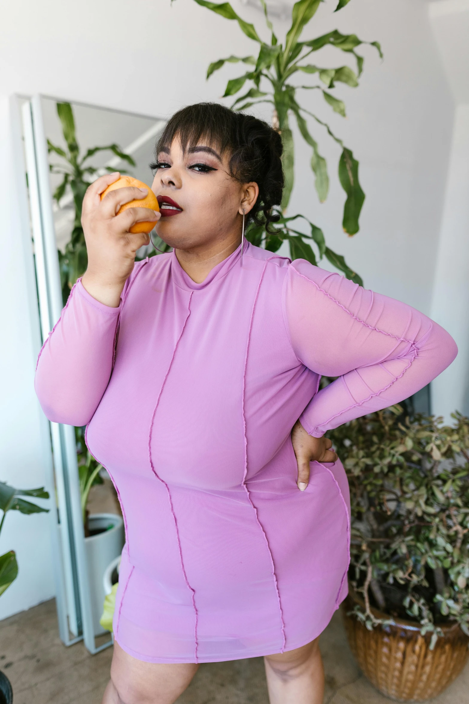 a woman in a purple dress eating a donut, inspired by Daphne McClure, trending on pexels, clear curvy details, non binary model, juice, hand on hips