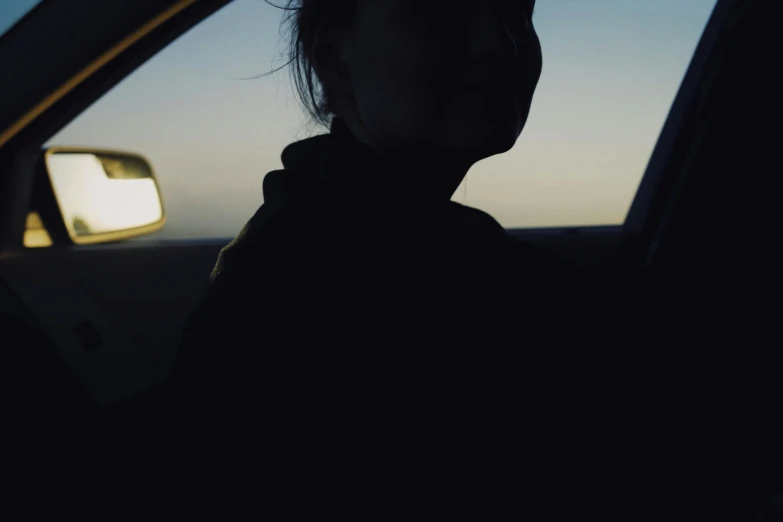 a woman sitting in the back seat of a car, inspired by Elsa Bleda, unsplash, silhouette :7, low quality photo, cinematic footage