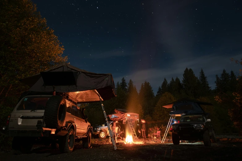 a group of people sitting around a campfire, auto-destructive art, underneath the stars, off-roading, cascadia, slide show