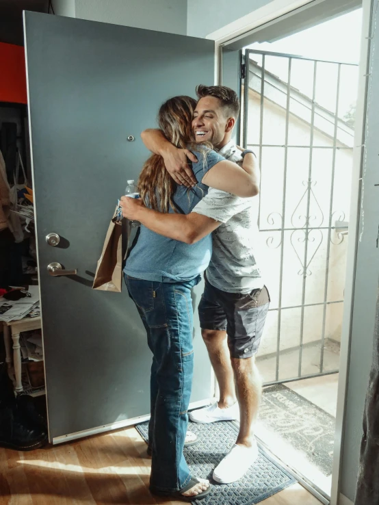 a man and a woman hugging in front of a door, pexels contest winner, happening, leaving a room, happy friend, julian ope, ryan dening